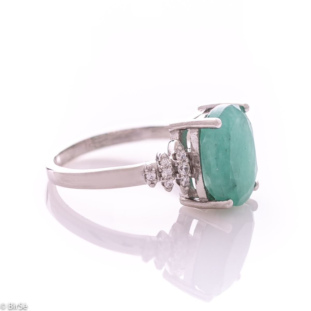 An exquisite women's ring with exceptional workmanship entirely of rhodium-plated silver, combined with a radiant natural emerald and sparkling zircons. Can be combined with earrings and pendant of the same model.