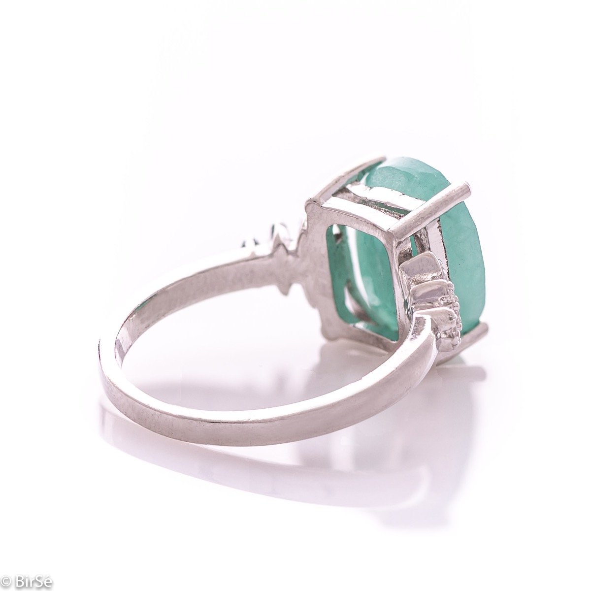 An exquisite women's ring with exceptional workmanship entirely of rhodium-plated silver, combined with a radiant natural emerald and sparkling zircons. Can be combined with earrings and pendant of the same model.