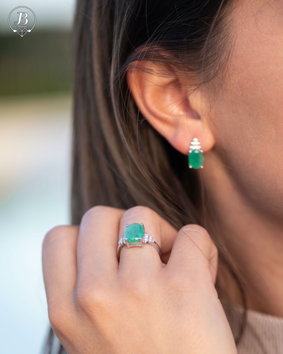 An exquisite women's ring with exceptional workmanship entirely of rhodium-plated silver, combined with a radiant natural emerald and sparkling zircons. Can be combined with earrings and pendant of the same model.