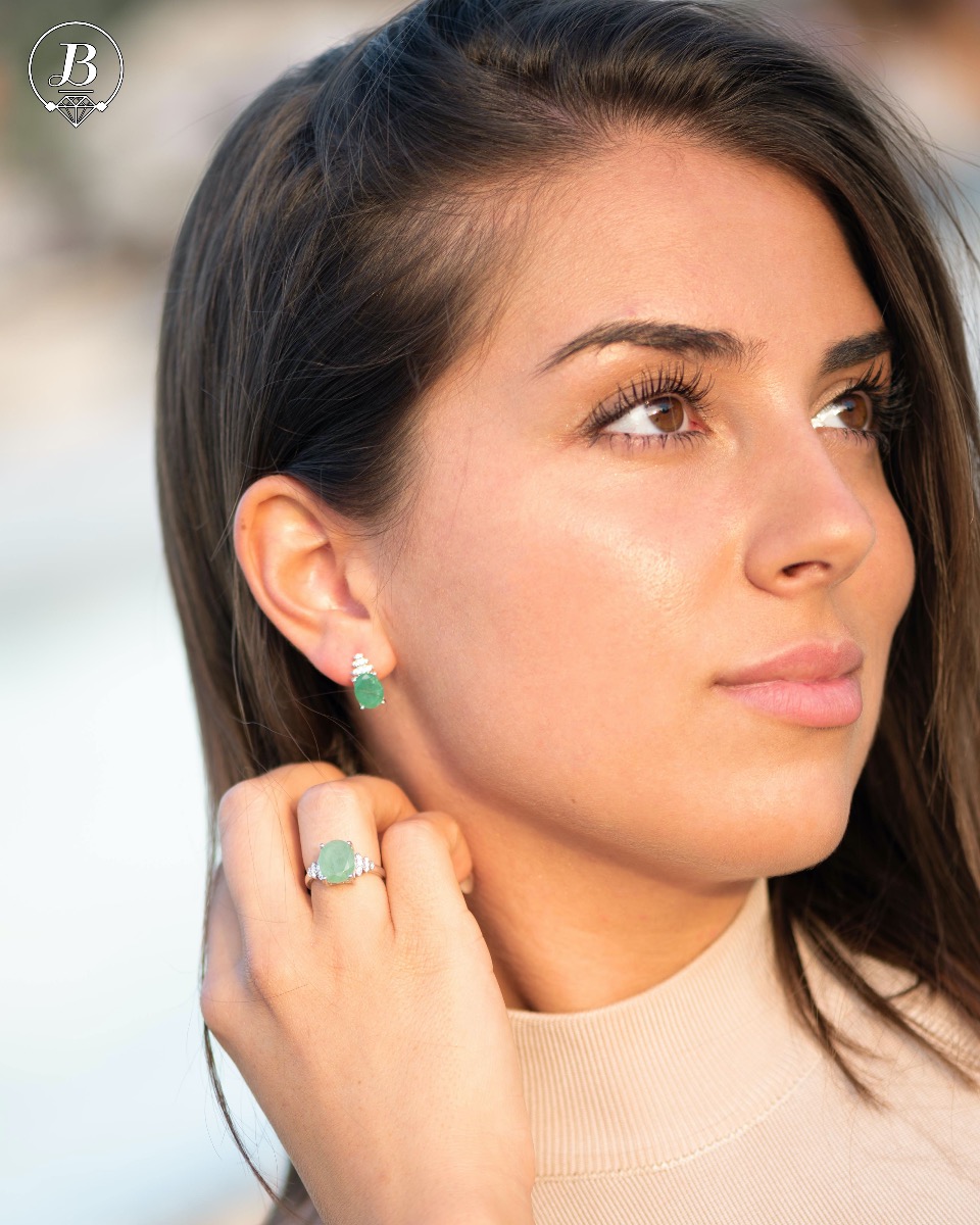 An exquisite women's ring with exceptional workmanship entirely of rhodium-plated silver, combined with a radiant natural emerald and sparkling zircons. Can be combined with earrings and pendant of the same model.