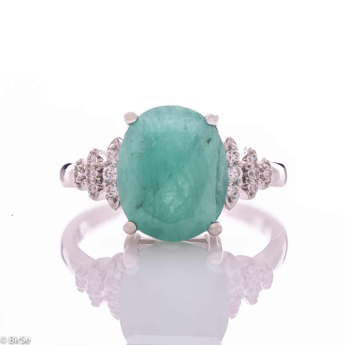 An exquisite women's ring with exceptional workmanship entirely of rhodium-plated silver, combined with a radiant natural emerald and sparkling zircons. Can be combined with earrings and pendant of the same model.