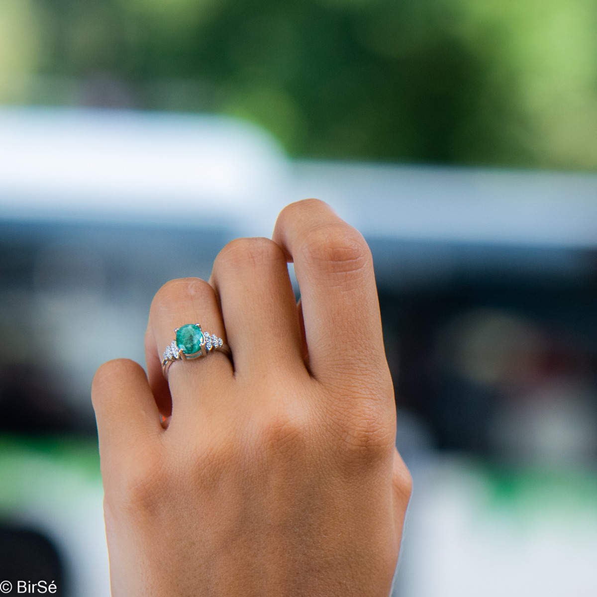 An exquisite women's ring with exceptional workmanship entirely of rhodium-plated silver, combined with a radiant natural emerald and sparkling zircons. Can be combined with earrings and pendant of the same model.