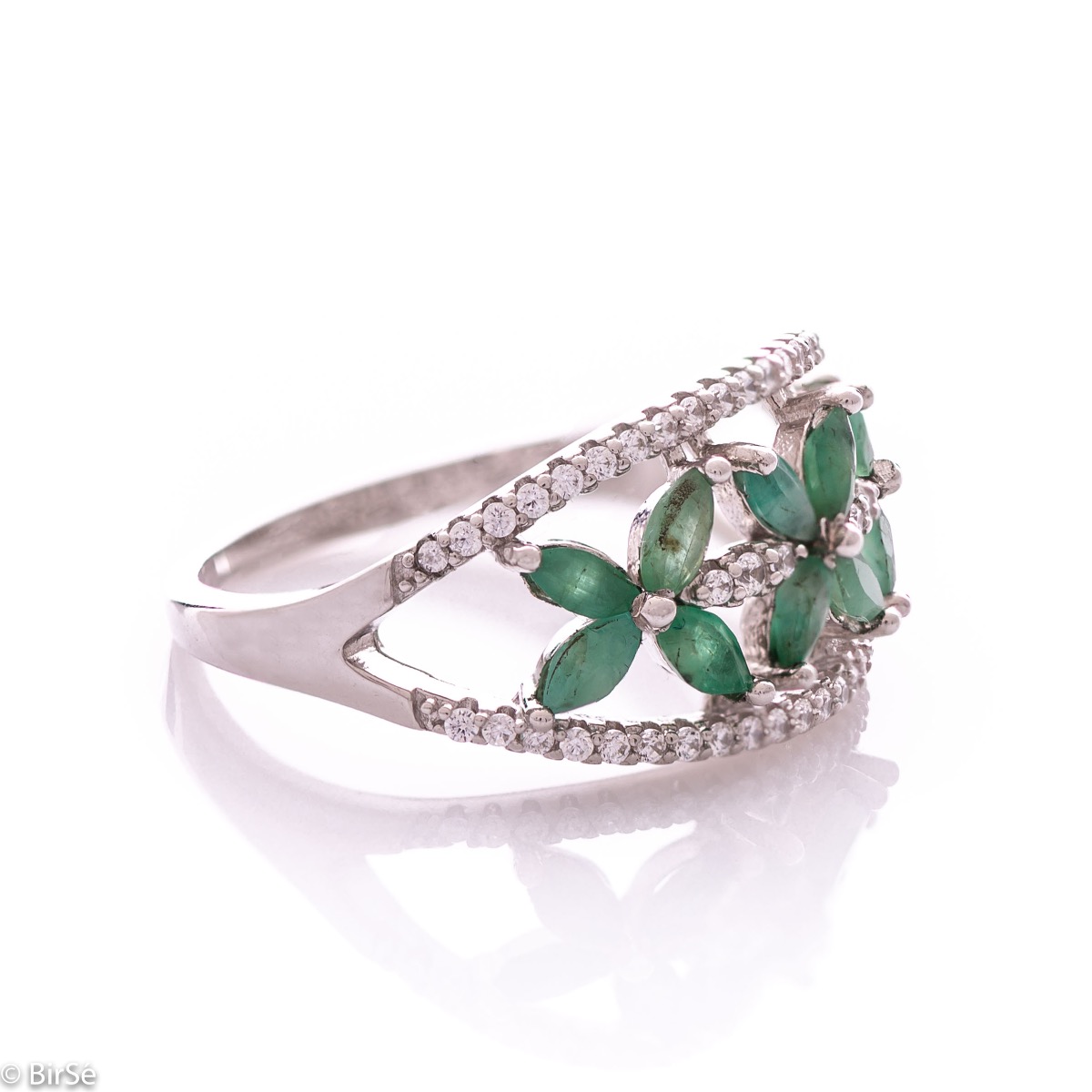 An elegant women's ring with a spectacular workmanship entirely of rhodium-plated silver, combined with delicate flowers of natural emerald and zircons. Can be combined with earrings and pendant of the same model.