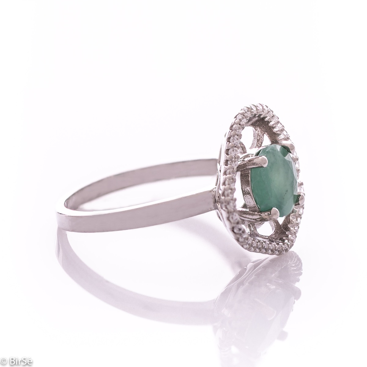 An exquisite women's ring with exceptional workmanship combining a radiant natural emerald with sparkling zircons and delicate rhodium silver. Can be combined with earrings and pendant of the same model.