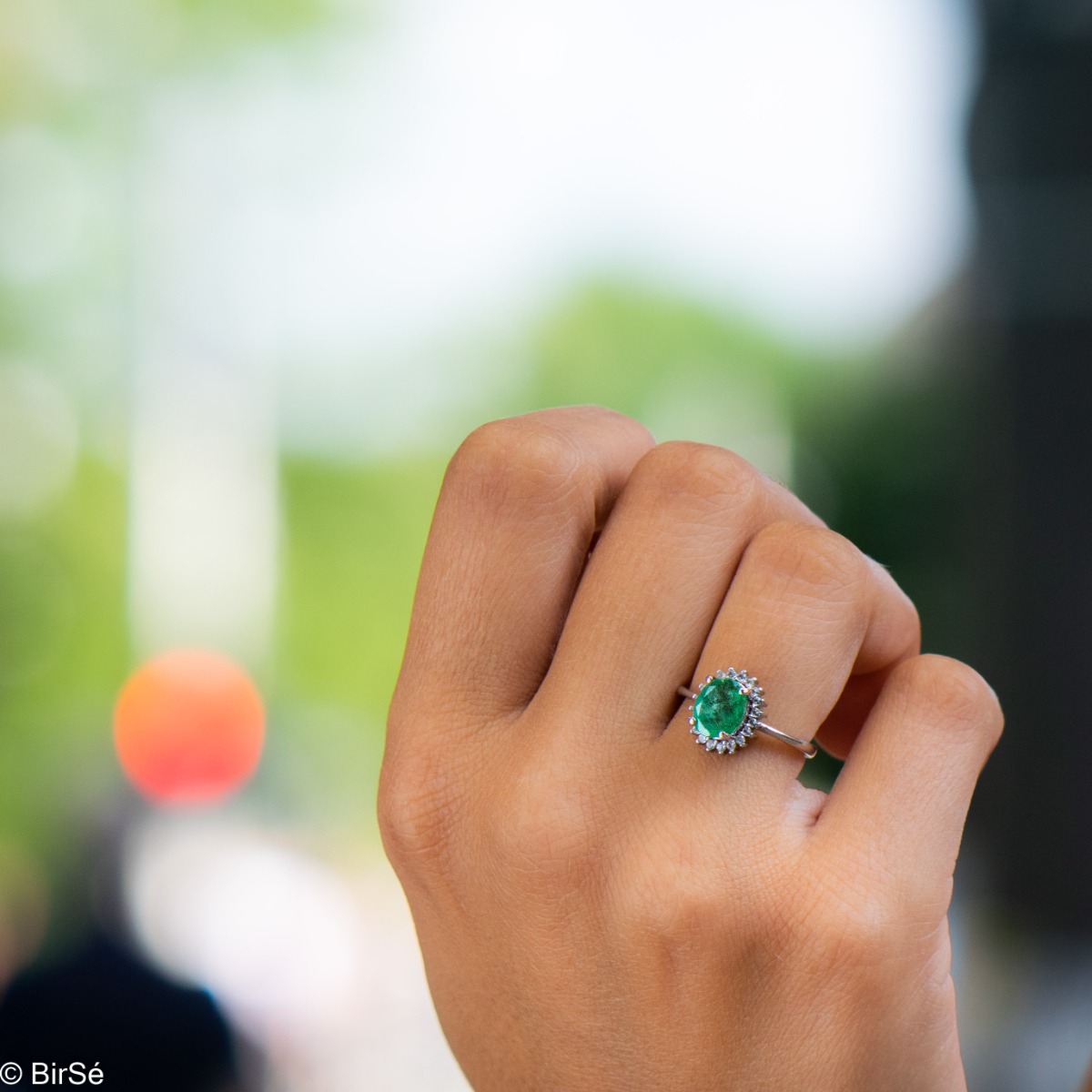 A radiant women's ring with delicate craftsmanship entirely in rhodium-plated silver, complemented by a unique natural emerald stone and the sparkle of fine zircons. Part of an exclusive set with a delicate pendant and earrings.