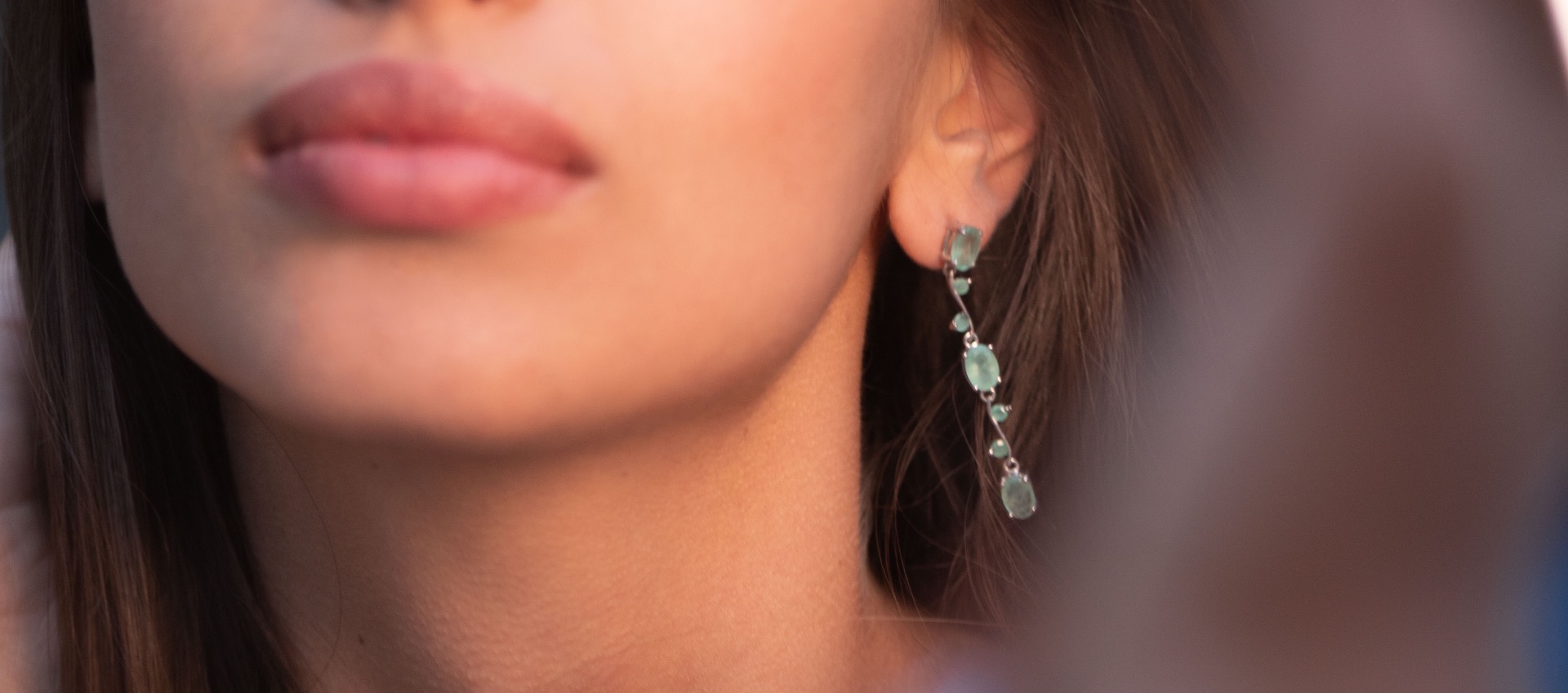 Extremely impressive dangling earrings with delicate workmanship combining numerous natural emerald stones with shiny rhodium silver.