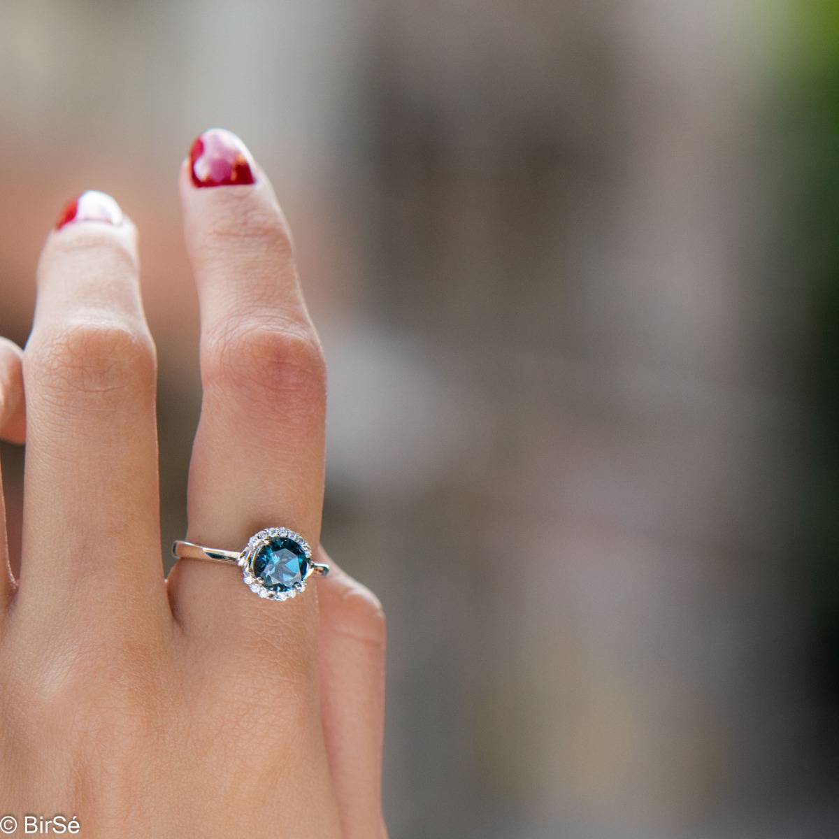 Delicately elegant women's ring made entirely of rhodium-plated silver, exquisite London topaz and the sparkle of fine zircons. It is suitable for combining in a set with earrings and a pendant from the same stylish collection.