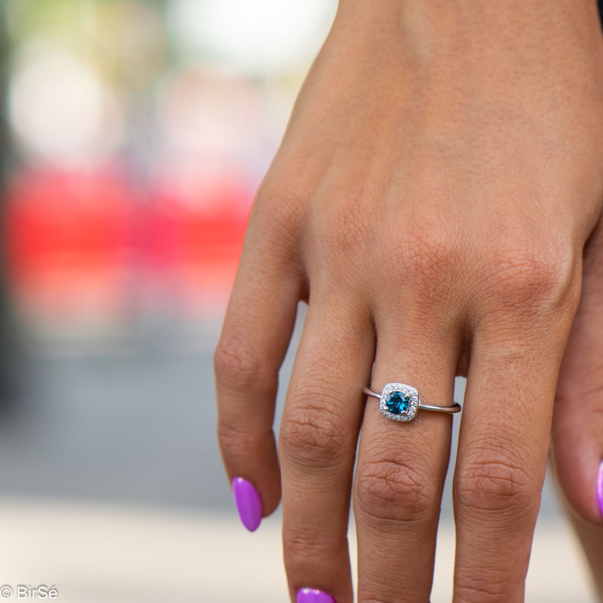 An elegant women's ring with extremely delicate details made of rhodium silver, natural London topaz and sparkling zircon stones. It is suitable for combining in a set with earrings and a pendant from the same collection and the same unique design.