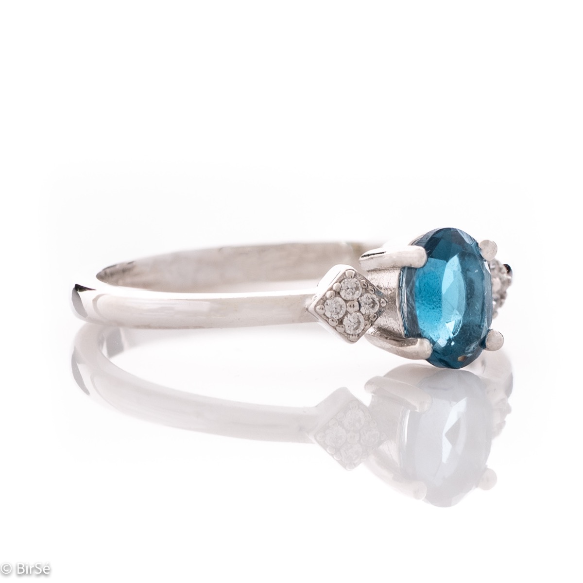 An exquisite women's ring with exceptional workmanship entirely of delicate rhodium silver, combined with a radiant natural stone London topaz and sparkling zircons. It can be combined with earrings and a delicate pendant.