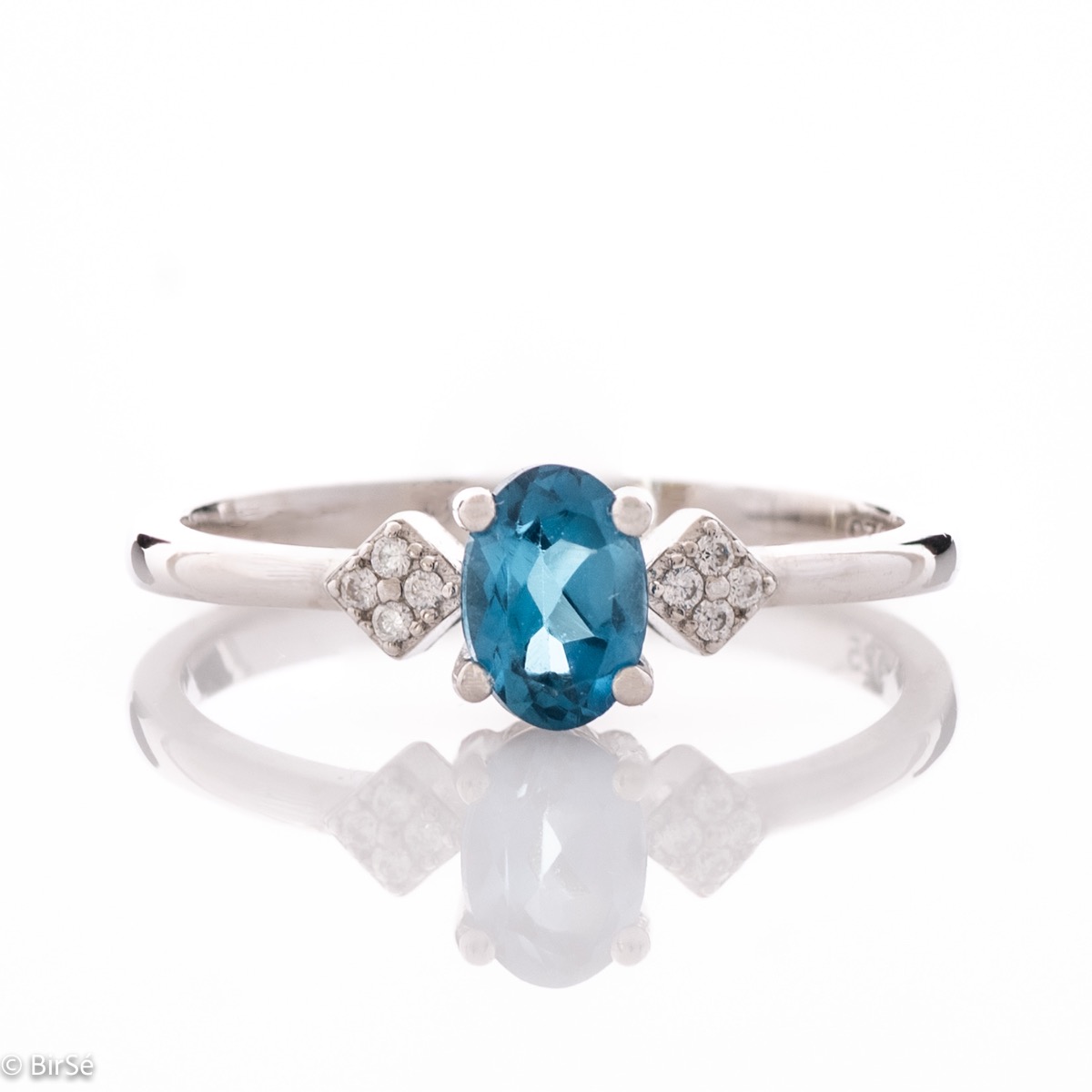 An exquisite women's ring with exceptional workmanship entirely of delicate rhodium silver, combined with a radiant natural stone London topaz and sparkling zircons. It can be combined with earrings and a delicate pendant.