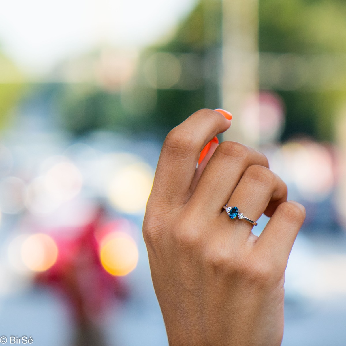 An exquisite women's ring with exceptional workmanship entirely of delicate rhodium silver, combined with a radiant natural stone London topaz and sparkling zircons. It can be combined with earrings and a delicate pendant.