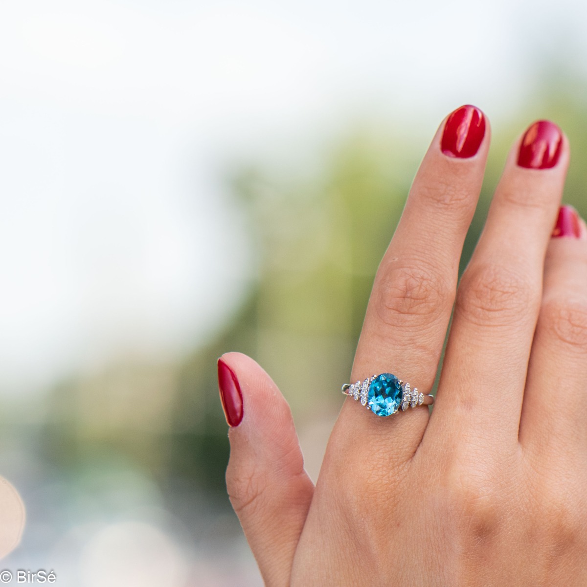 An elegant lady's ring with a stylish design and precise craftsmanship entirely of rhodium-plated silver combined with a radiant natural London topaz and sparkling zircons.