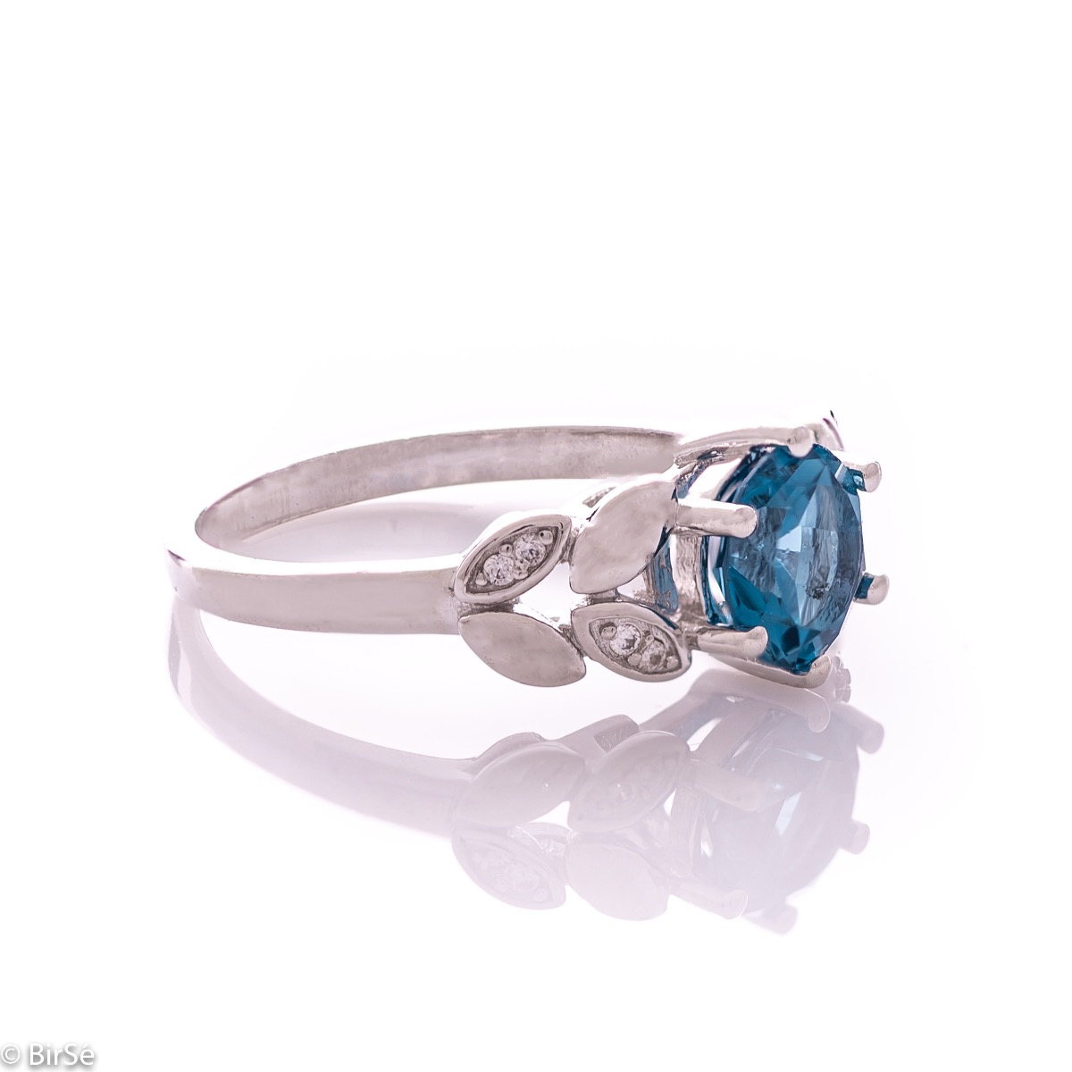 Elegant women's ring with delicate craftsmanship combining refined rhodium-plated silver with radiant natural London topaz and petals of sparkling zircons. Can be combined with earrings and pendant of the same model.