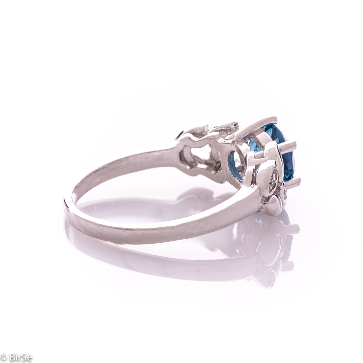 Elegant women's ring with delicate craftsmanship combining refined rhodium-plated silver with radiant natural London topaz and petals of sparkling zircons. Can be combined with earrings and pendant of the same model.