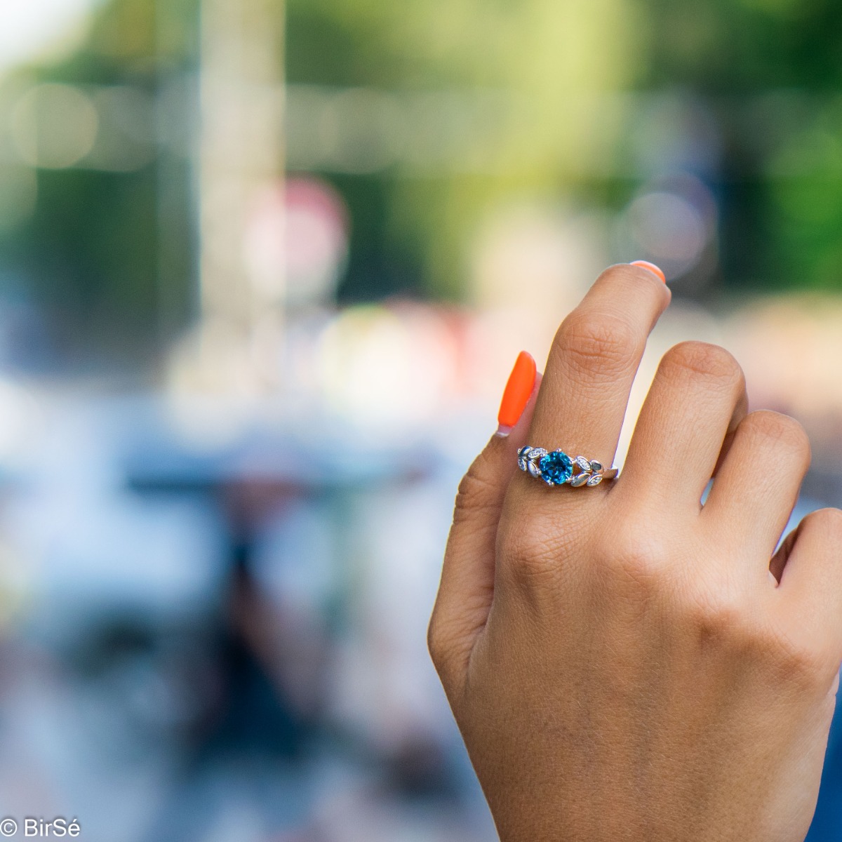 Elegant women's ring with delicate craftsmanship combining refined rhodium-plated silver with radiant natural London topaz and petals of sparkling zircons. Can be combined with earrings and pendant of the same model.