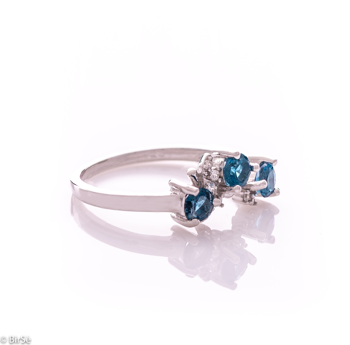 An elegant women's ring with a charming design, combining three brilliant natural London topaz stones with sparkling zircons and precision craftsmanship entirely in rhodium-plated silver. Can be combined with earrings and pendant of the same model.