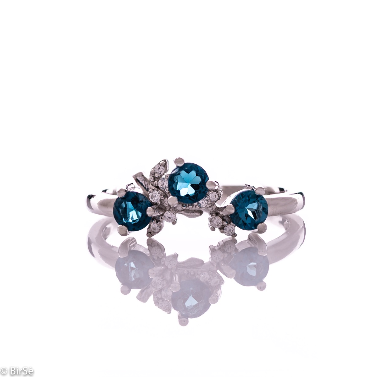 An elegant women's ring with a charming design, combining three brilliant natural London topaz stones with sparkling zircons and precision craftsmanship entirely in rhodium-plated silver. Can be combined with earrings and pendant of the same model.