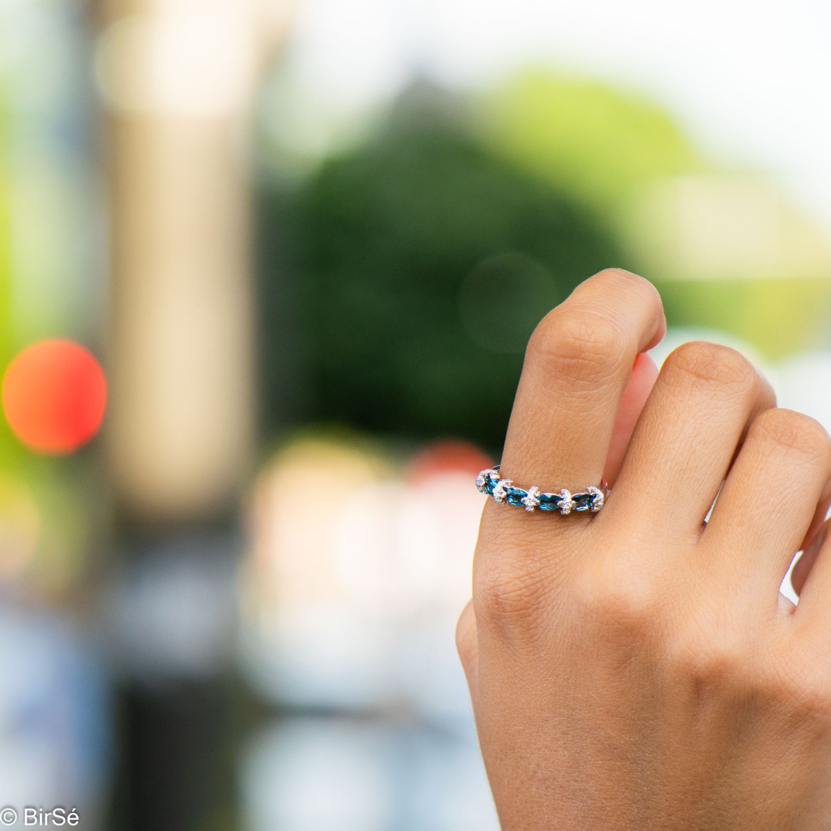 Delicate women's ring interweaving radiant natural London topaz with sparkling zircons and exquisite workmanship entirely in rhodium-plated silver.