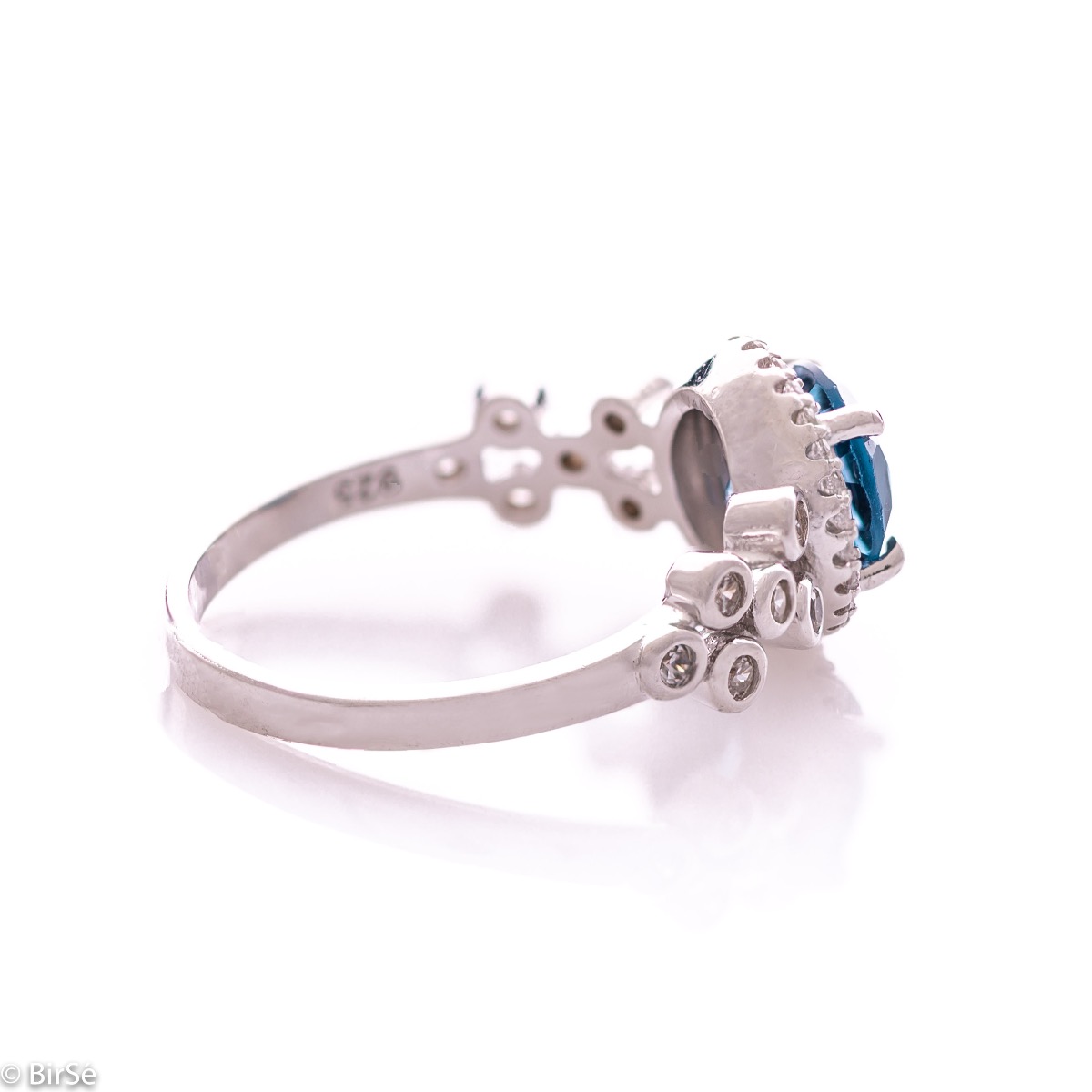 An elegant women's ring with a spectacular craftsmanship entirely of rhodium-plated silver, combined with a radiant natural London topaz and sparkling zircons. Can be combined with earrings and pendant of the same model.