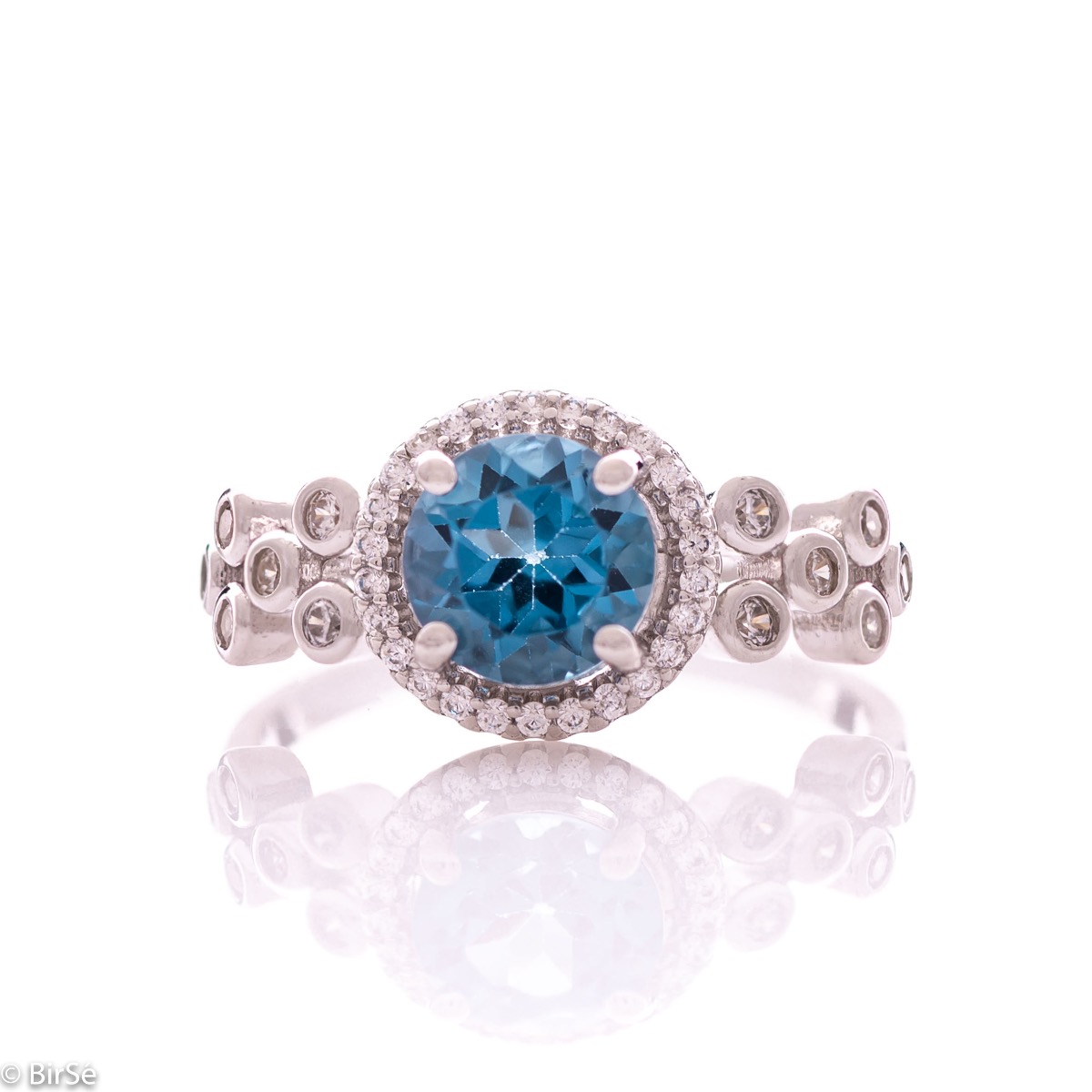 An elegant women's ring with a spectacular craftsmanship entirely of rhodium-plated silver, combined with a radiant natural London topaz and sparkling zircons. Can be combined with earrings and pendant of the same model.