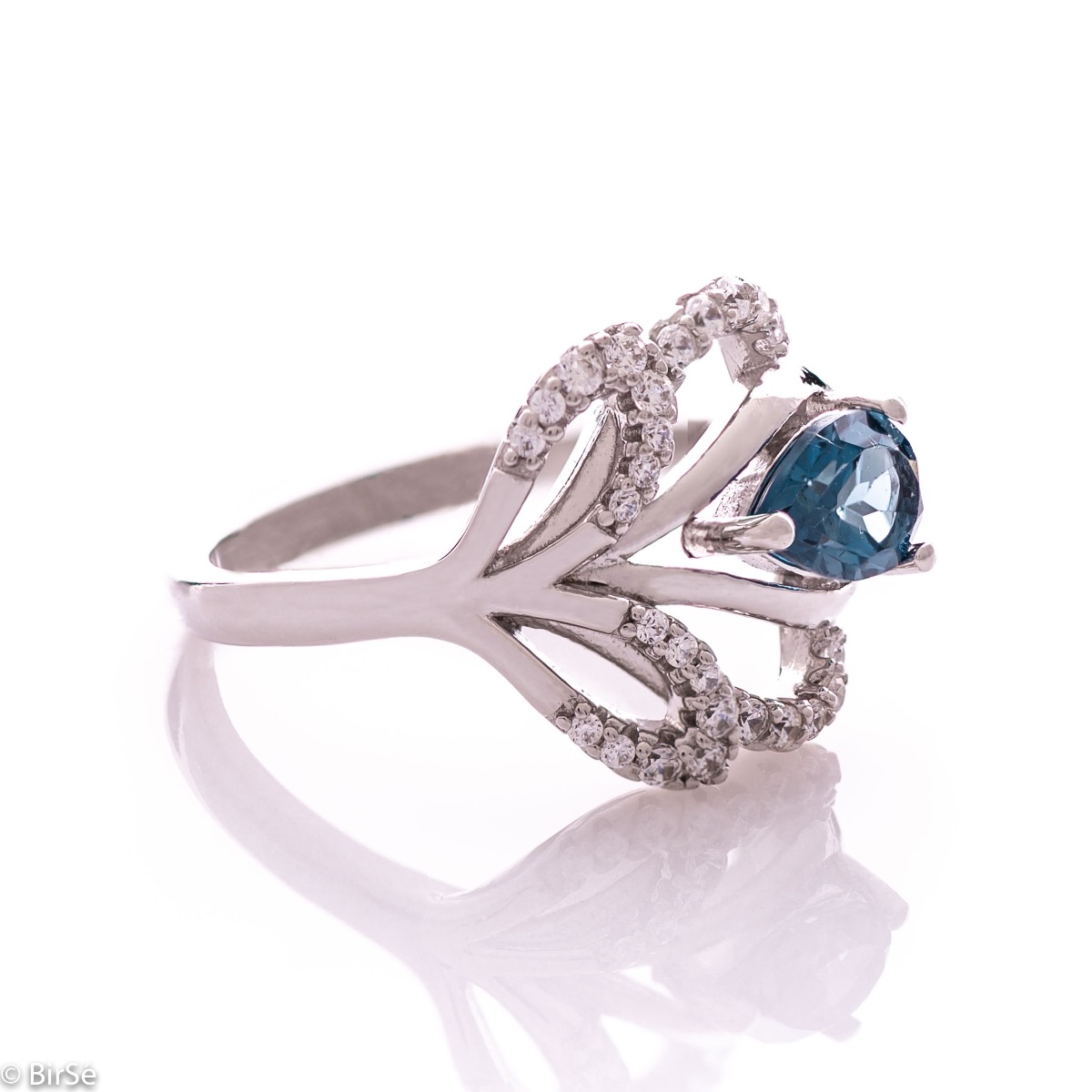 A spectacular women's ring with gentle curves and exquisite workmanship entirely of rhodium-plated silver combined with natural London topaz and sparkling zircons. Can be combined with earrings and pendant of the same model.