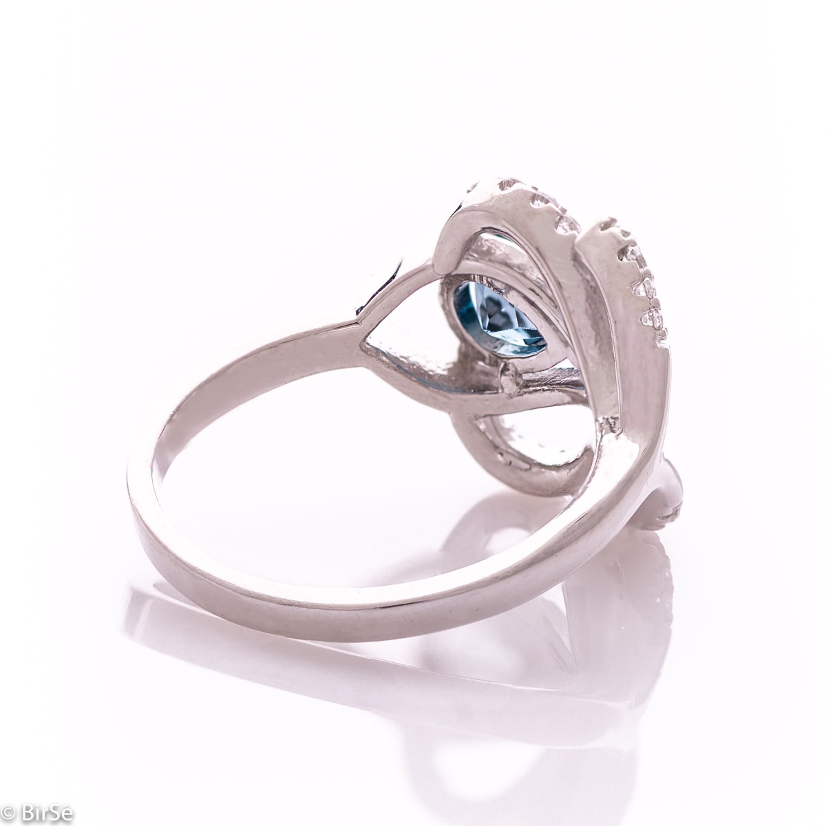 A spectacular women's ring with gentle curves and exquisite workmanship entirely of rhodium-plated silver combined with natural London topaz and sparkling zircons. Can be combined with earrings and pendant of the same model.