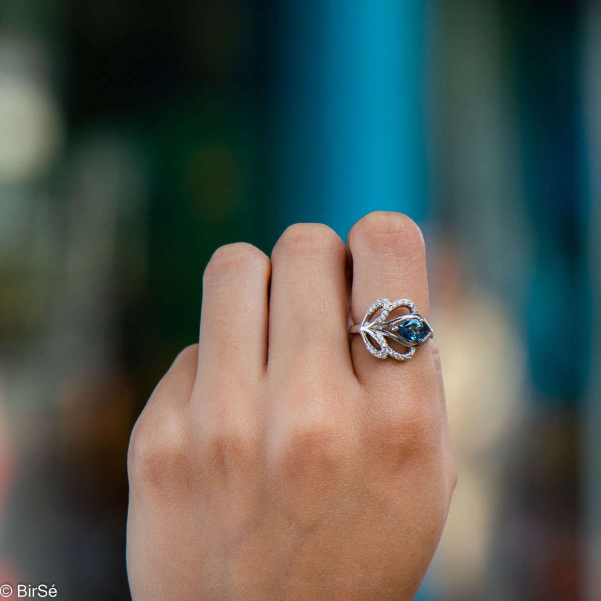 A spectacular women's ring with gentle curves and exquisite workmanship entirely of rhodium-plated silver combined with natural London topaz and sparkling zircons. Can be combined with earrings and pendant of the same model.