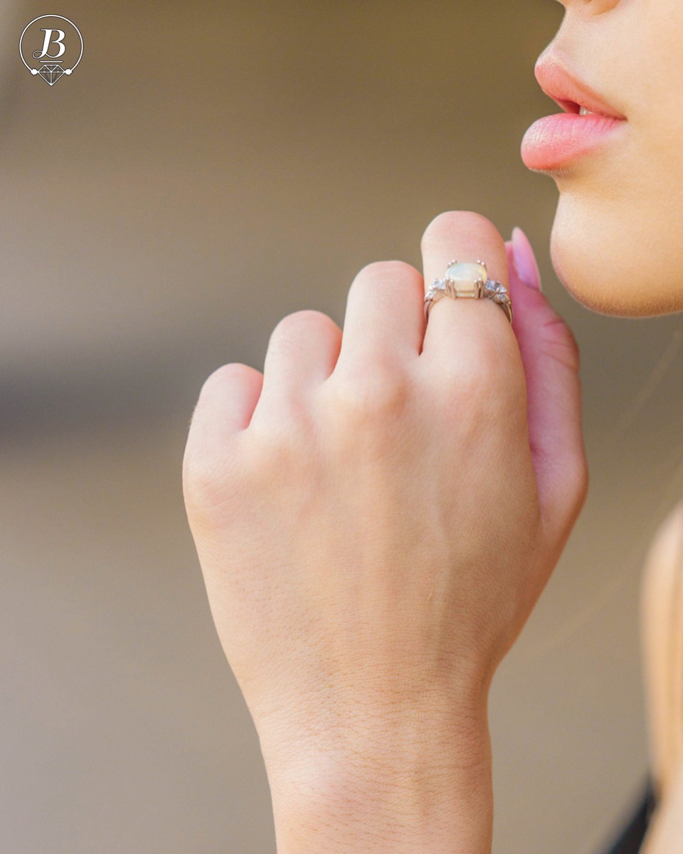 An elegant ring of rhodium-plated silver and natural opal with an oval shape, in the company of delicate zircon stones. Make your look even more spectacular with a pendant and earrings from the same collection.