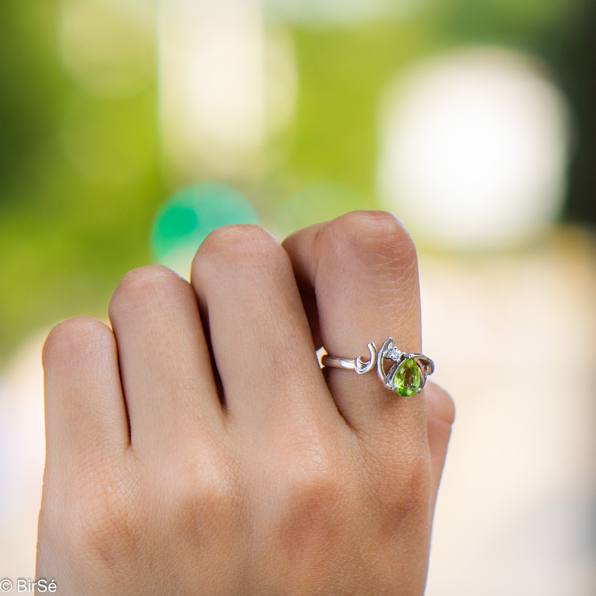 Spectacular and radiant women's ring with a natural peridot stone, in a delicate teardrop shape, complemented by a sparkling zircon and fine workmanship of beautiful rhodium silver. In an exclusive set with earrings and pendant.