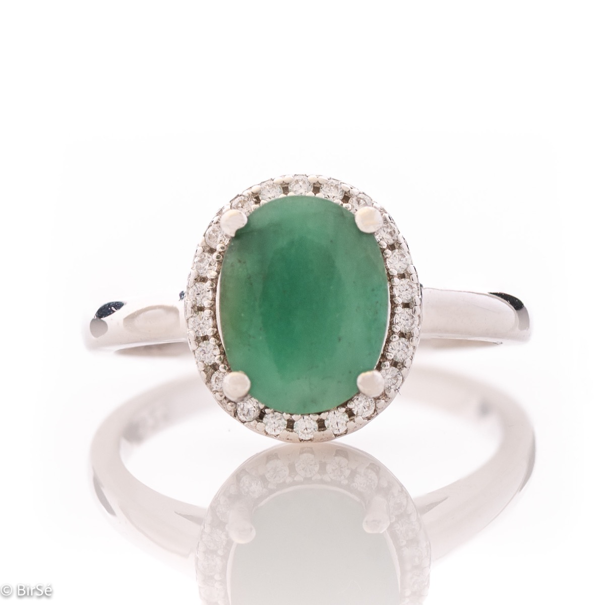 An elegant women's ring with a delicate natural emerald stone, complemented by the sparkle of fine zircons and beautiful craftsmanship entirely in rhodium-plated silver. In a charming set with matching earrings and necklace.