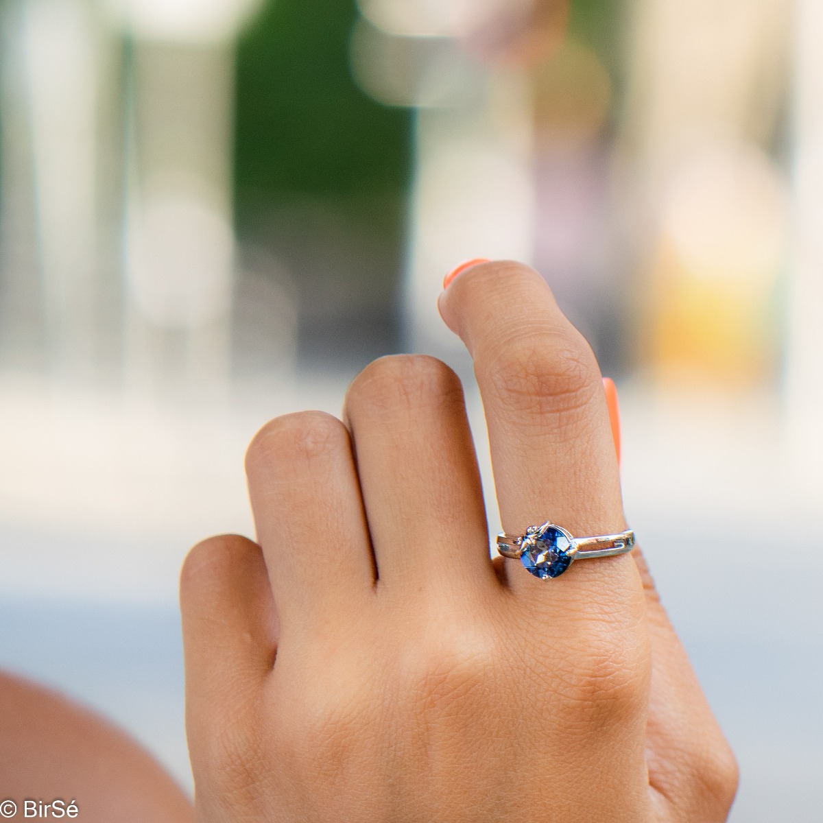 An elegant women's ring with a sparkling natural blue mystic topaz stone, intertwined with beautiful curves made entirely of elegant rhodium-plated silver.