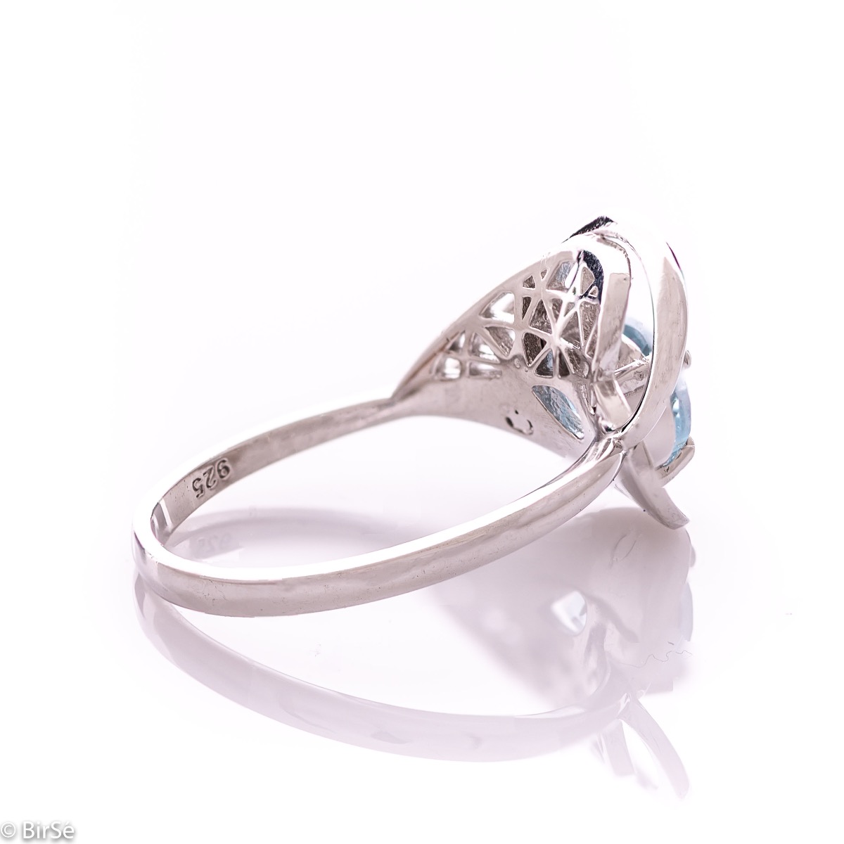 A spectacular women's ring with delicate workmanship entirely of rhodium-plated silver, resembling a heart intertwined with a radiant natural stone blue topaz. It can be combined with a pendant and earrings of the same model.