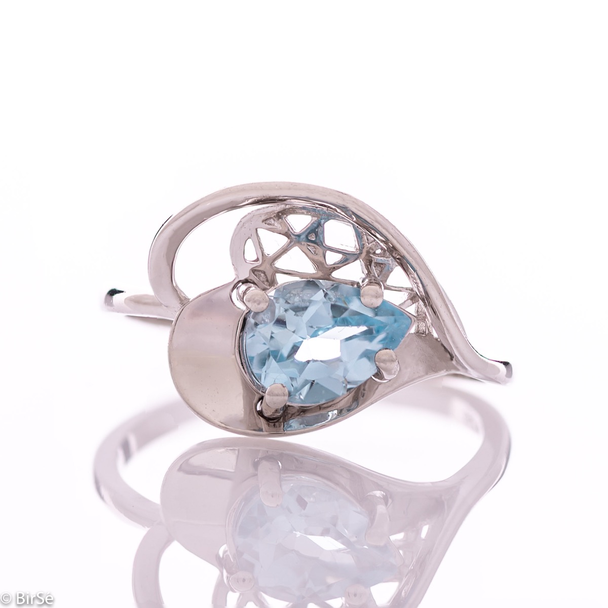 A spectacular women's ring with delicate workmanship entirely of rhodium-plated silver, resembling a heart intertwined with a radiant natural stone blue topaz. It can be combined with a pendant and earrings of the same model.