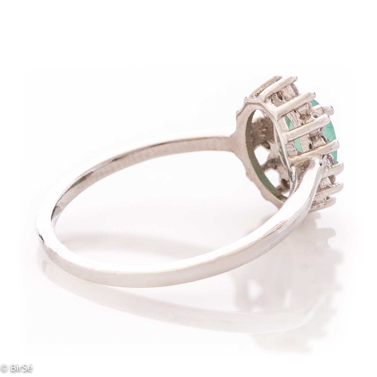 An elegant women's ring with delicate rhodium-plated sterling silver craftsmanship combined with a radiant emerald natural stone surrounded by sparkling zircons. Can be combined with earrings, necklace and bracelet of the same model.