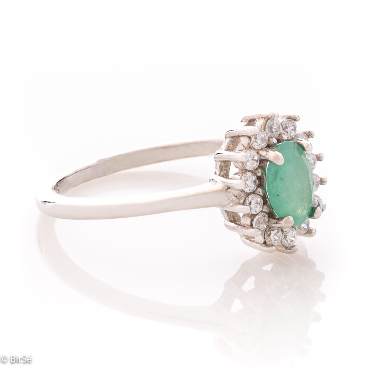 An elegant women's ring with delicate rhodium-plated sterling silver craftsmanship combined with a radiant emerald natural stone surrounded by sparkling zircons. Can be combined with earrings, necklace and bracelet of the same model.