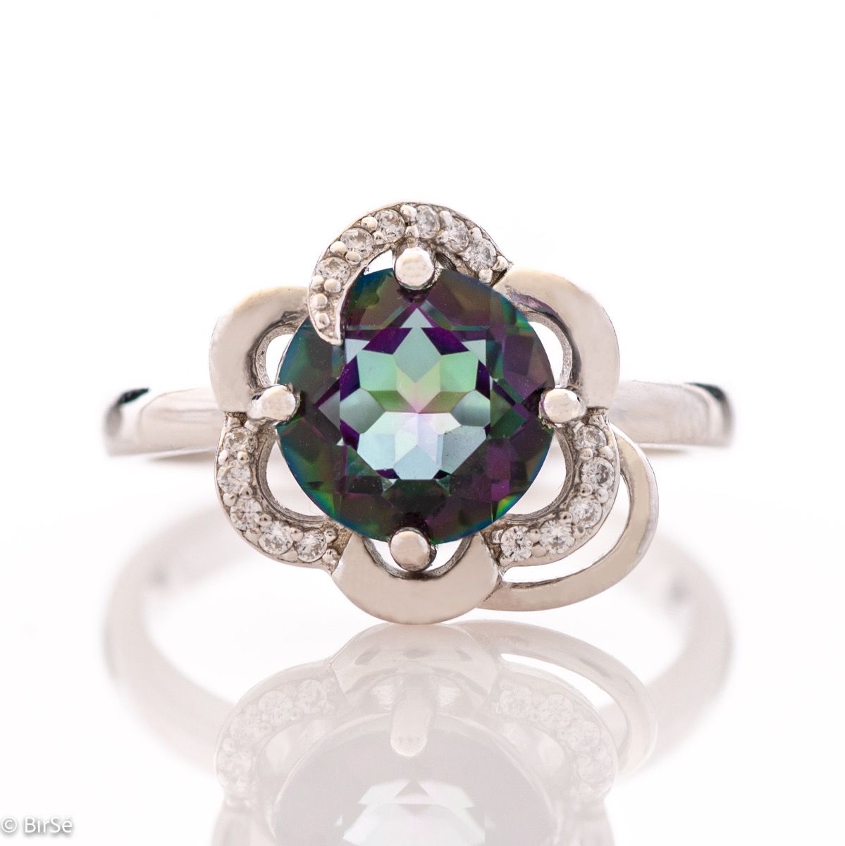 A unique women's ring with precise craftsmanship and delicate curves of rhodium-plated silver, surrounding a sparkling natural stone, mystic topaz and delicate zircons. Part of a charming pendant and earring set.