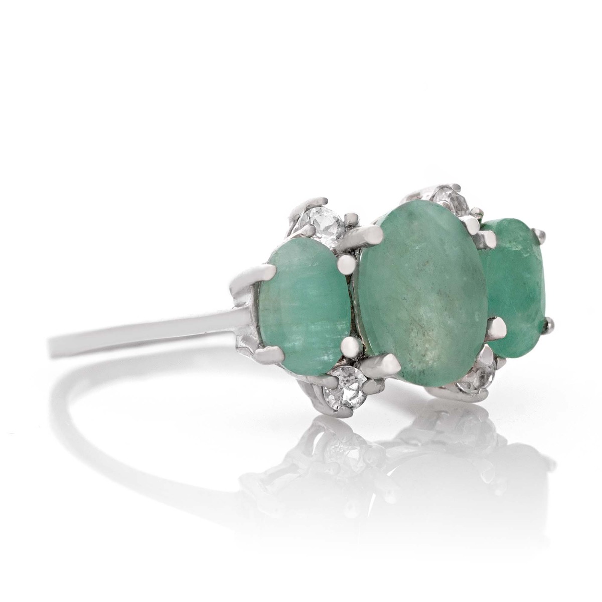 An elegant ladies' ring design crafted from beautiful rhodium-plated sterling silver that gently envelops a trio of natural emeralds. With the glamorous presence of white zircons that add extra charm to the jewelry.