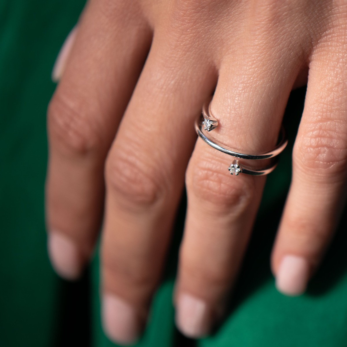 An elegant and captivating women's ring made entirely of shiny rhodium silver with an interesting design and two delicate zircons.