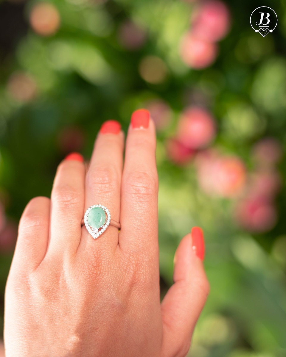 An elegant women's ring with spectacular craftsmanship combining refined rhodium-plated silver with a radiant natural emerald and sparkling zircons. Can be combined with earrings and pendant of the same model.