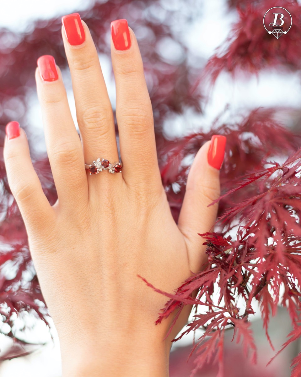 An elegant women's ring with a charming design, combining three radiant natural garnet stones with sparkling zircons and precision craftsmanship entirely in rhodium-plated silver. Can be combined with earrings and pendant of the same model.