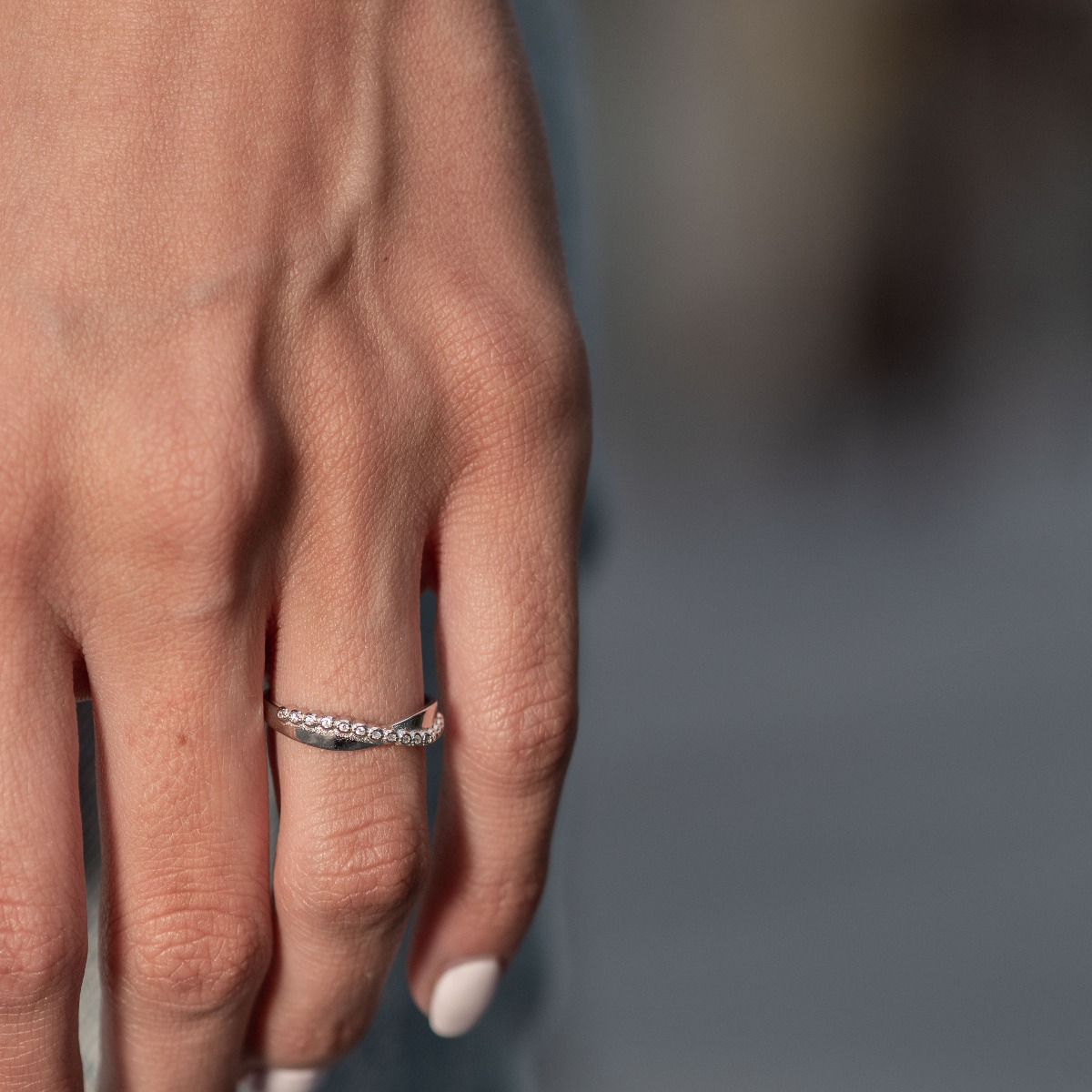 An elegant women's ring with gentle curves and precise craftsmanship entirely of rhodium-plated silver, complemented by fine zircons.