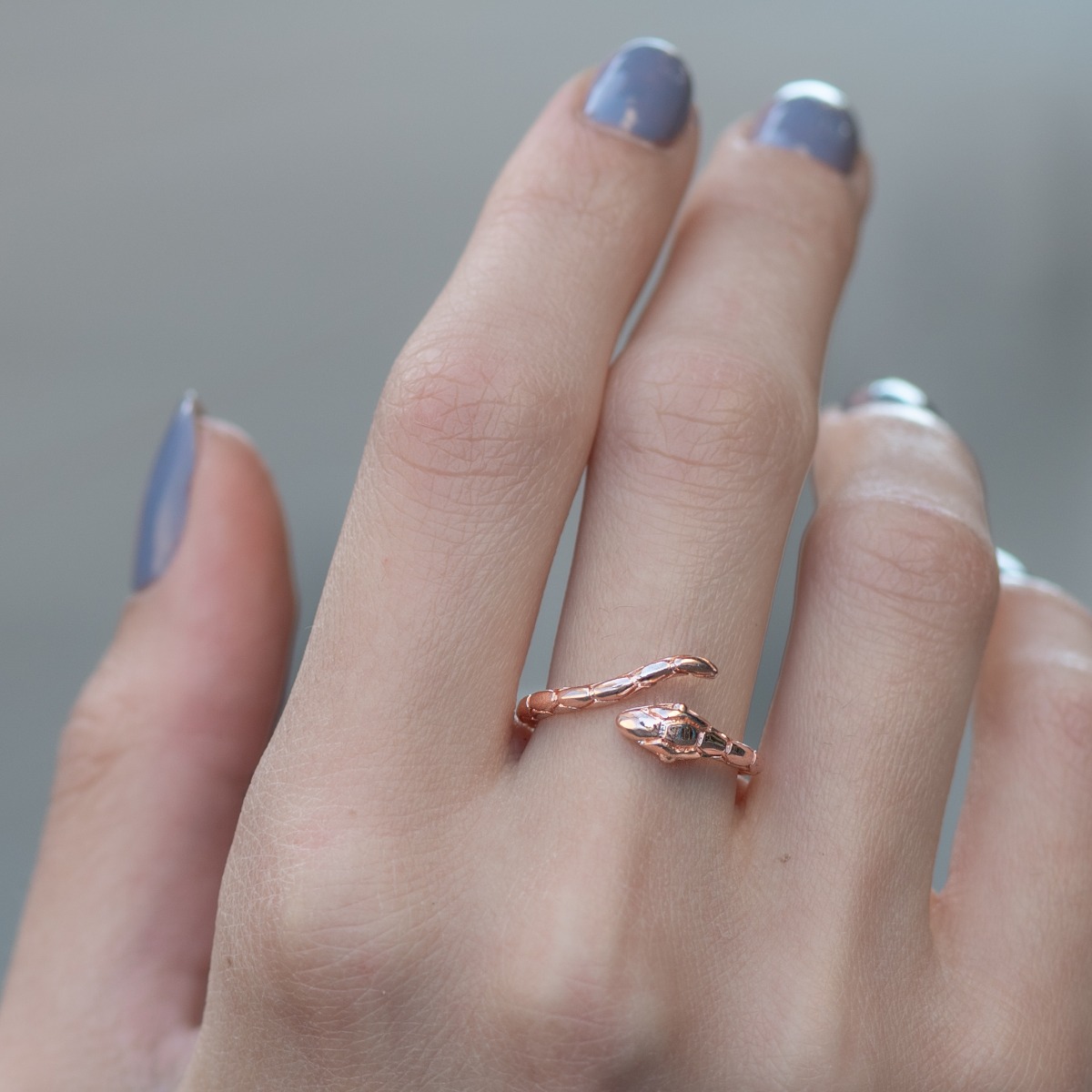 An original women's ring with a modern python design, made entirely of captivating rose silver and two zircons for sparkle. The ring has an open design, which allows for slight size adjustment.