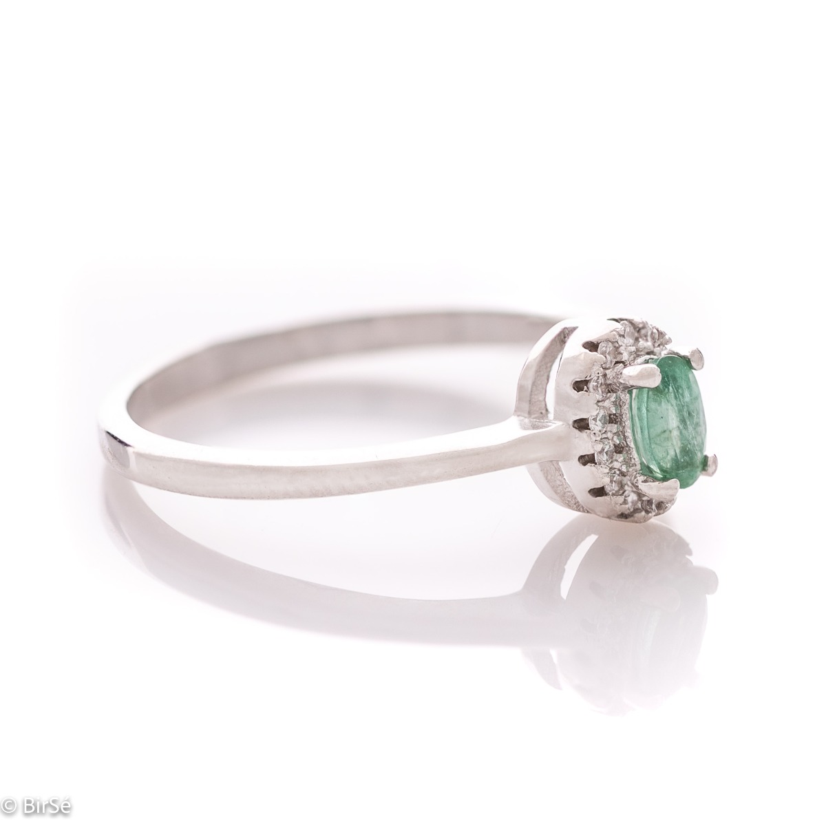 An elegant women's ring with a delicate natural emerald stone, complemented by the sparkle of fine zircons and beautiful craftsmanship entirely in rhodium-plated silver. In a charming set with matching earrings, bracelet and necklace.