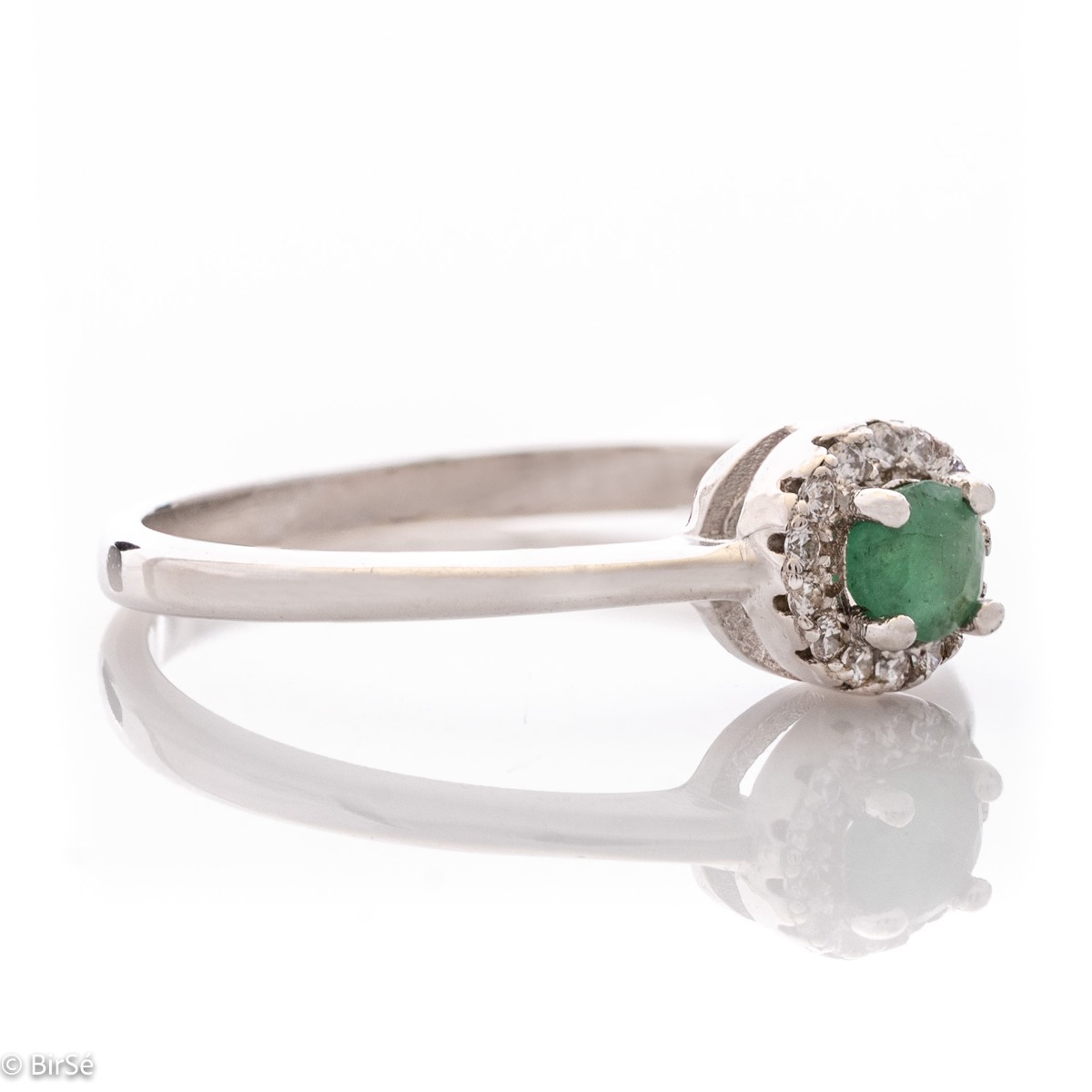 Delicate emerald shine - an extremely beautiful ladies ring with a round shape. Stylish craftsmanship from a fine combination of rhodium silver, fine emerald and sparkling zircons.