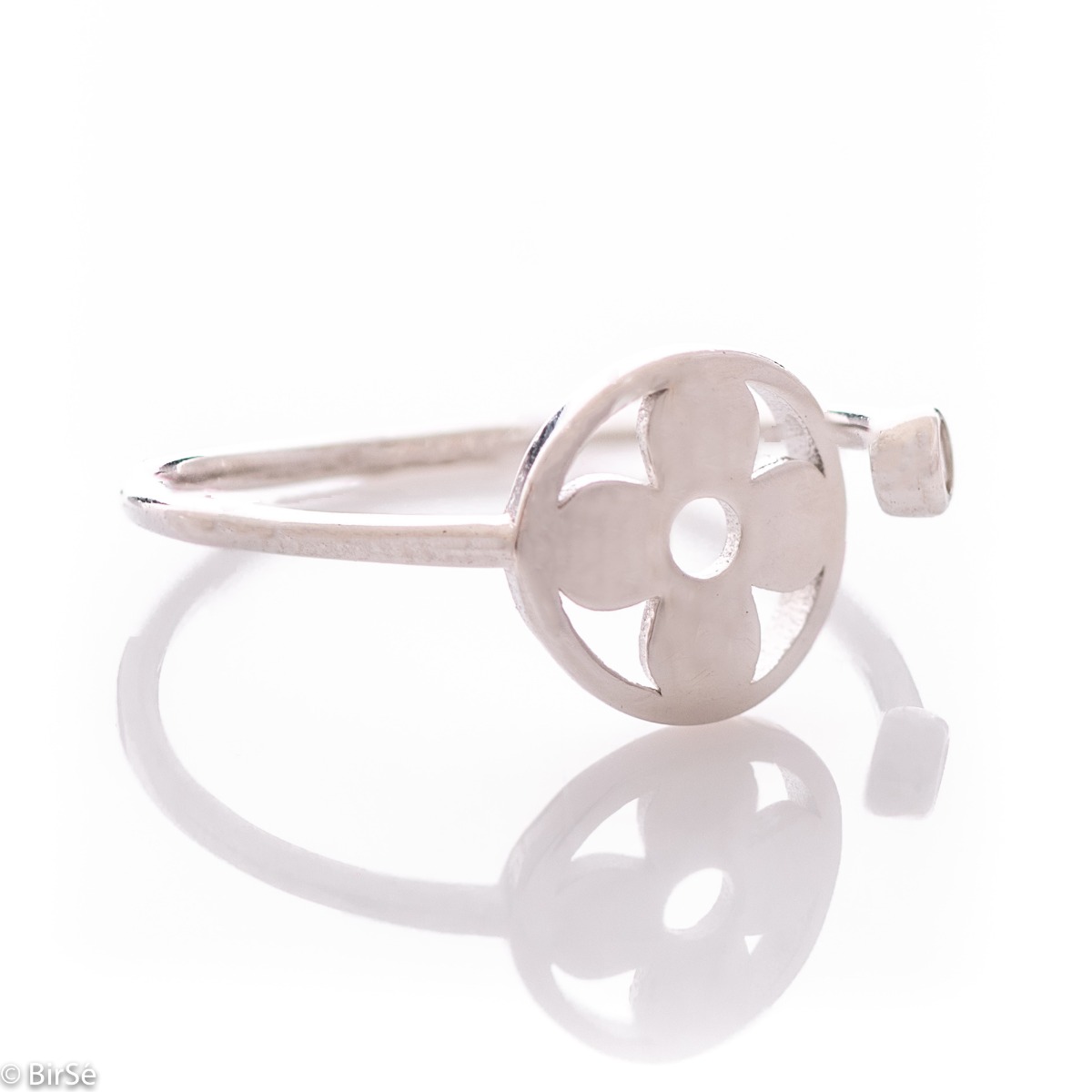 Beautifully crafted ring in sterling silver, adjustable pattern, ending at one end with a round element in the middle with a flower. At the other end, in a delicate fitting, a tiny zircon sparkles beautifully.