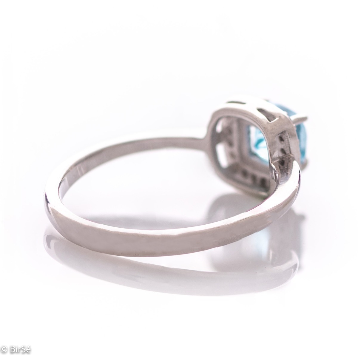 Tempting ring of rhodium-plated silver and natural blue topaz in the exquisite embrace of zircon stones.