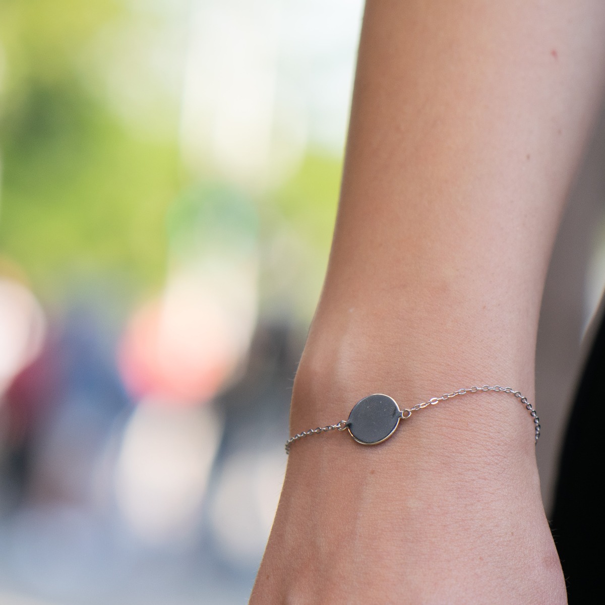 A simple bracelet in shiny rhodium silver with a plate, in a round shape. The jewelry makes a great gift and allows for engraving a letter or the date of an event.