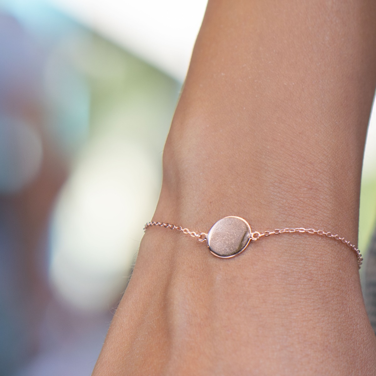 A simple round shape bracelet in shiny rose silver with a tile. The jewelry makes a great gift and allows for engraving a letter or the date of an event.