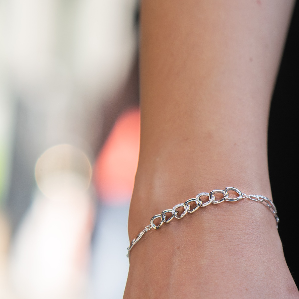 Captivating women's rhodium silver bangle with a striking design, rings decorated with zircons, held on both sides by a double chain of a different type. Jewelry is a great gift idea for any lady.