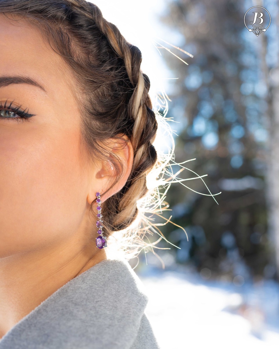 Radiant and spectacular dangling stud earrings with multi-faceted and variously shaped natural amethyst stones and delicately crafted from fine rhodium silver.